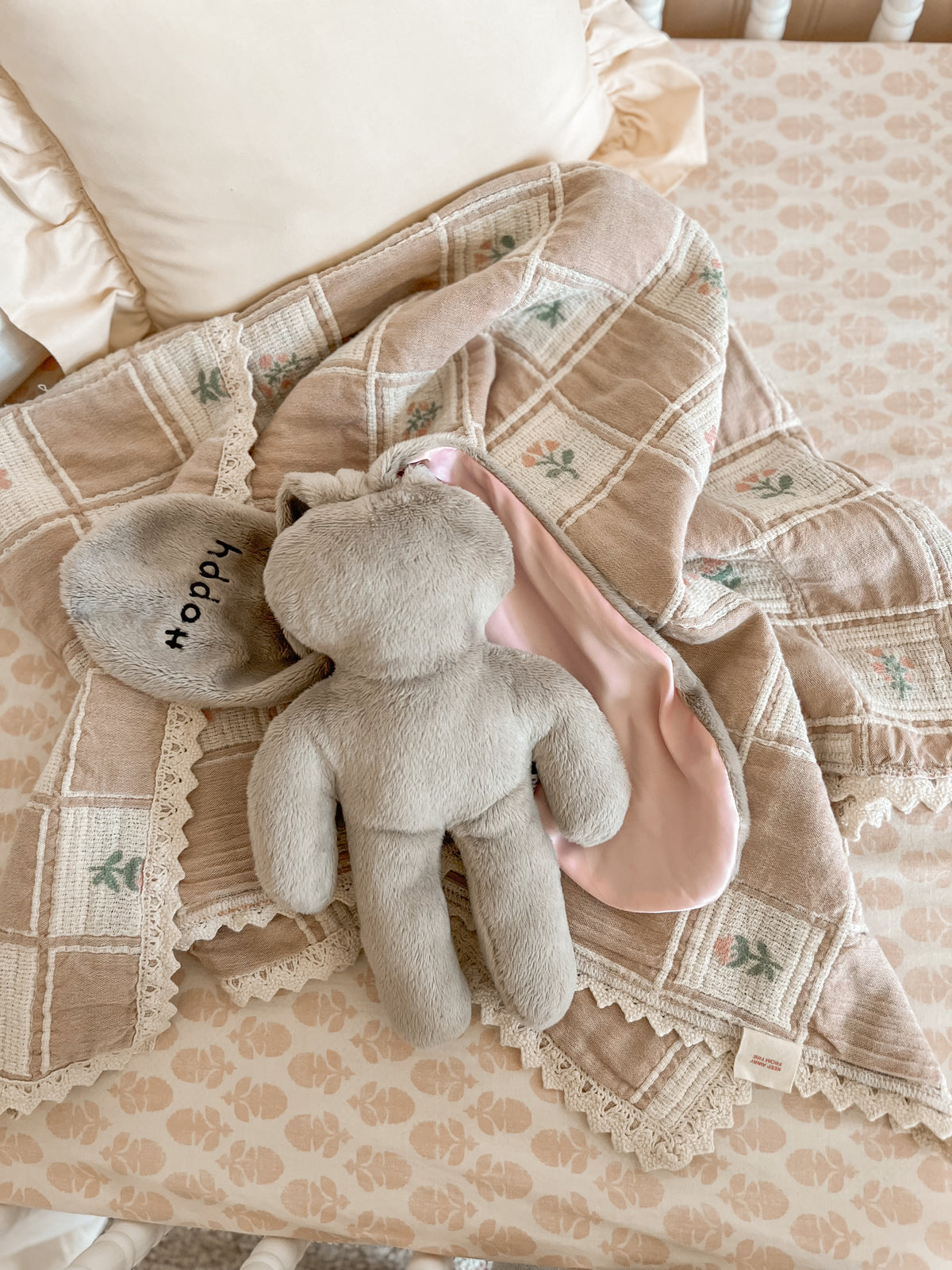 Soft Hoppy baby lovey bunny resting on a cozy nursery blanket, highlighting gentle textures and comforting design.